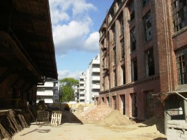 Przejście między budynkami pofabrycznymi - w tle I i II etap Barciński Park.